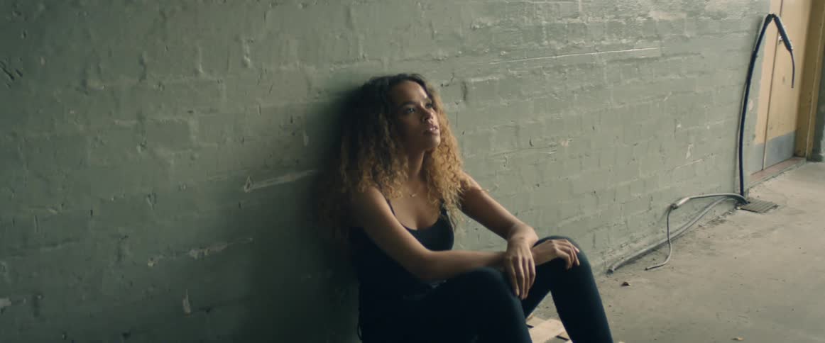 A woman is sitting in an empty room