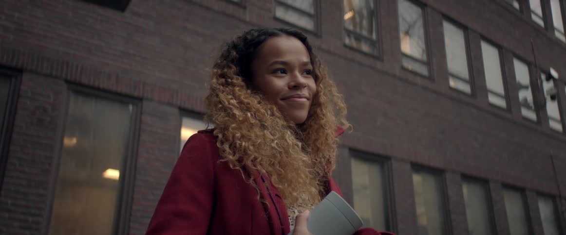 A teenage girl standing outside an apartment building
