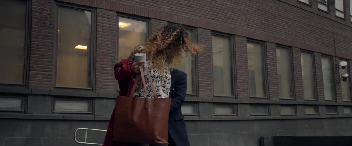 A man helps a woman put on her coat