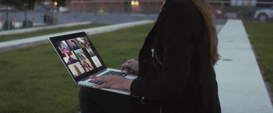 Woman on her laptop outside on a video call