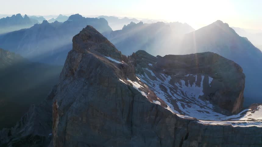 A mountain range with ice and snow with the sky and clouds in the background
