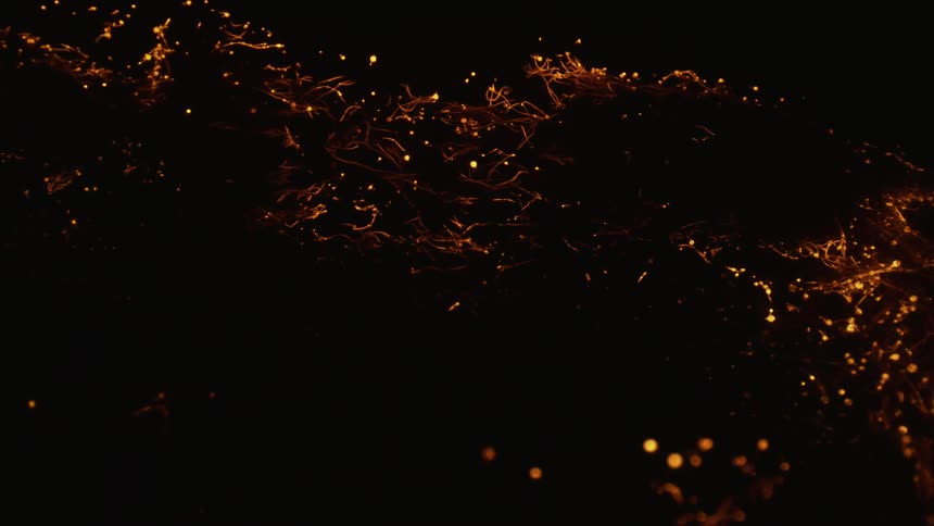 Low burning embers burn and float up and away causing shadows where cool