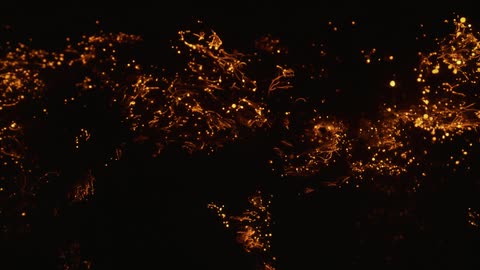 Ember glowing lights flicker scattering about back and forth between each other in dark enclosed area