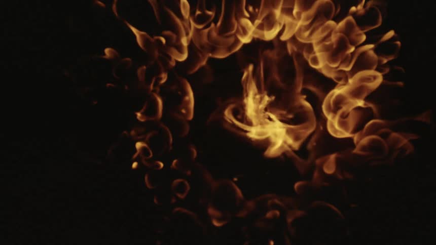 A flame of fire growing into more flames around it in the darkness