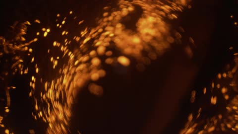 Gold sparks fly against a dark background