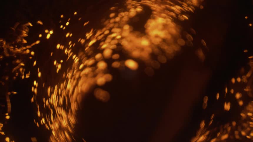 Gold sparks fly against a dark background