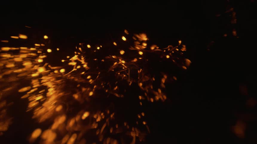 Embers on a burning object in the dark