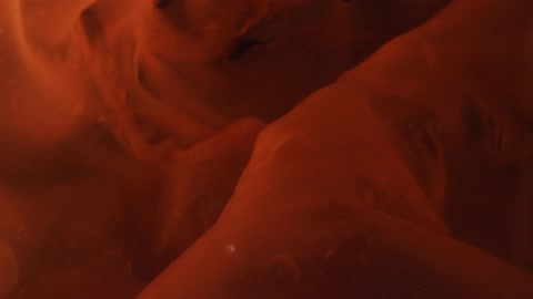 An object pulsing and rippling in liquid in the dark