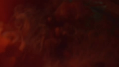 A small wave ripples over smoky red water