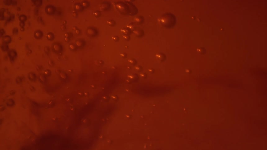 Bubbles rippling on the red ink floating in water