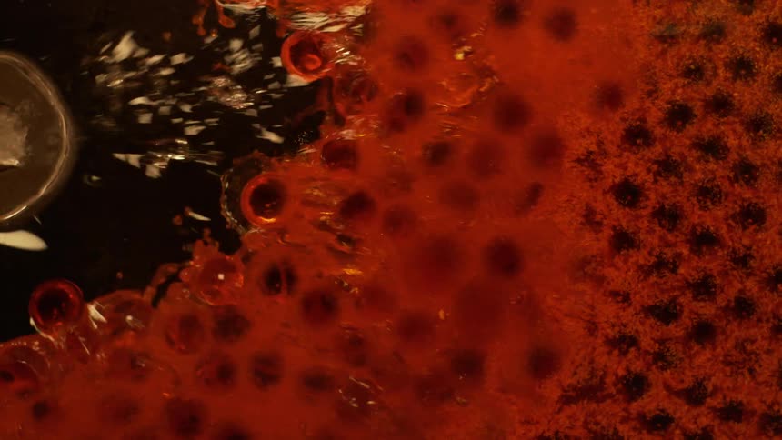 Glass balls covered in red ink floating in water