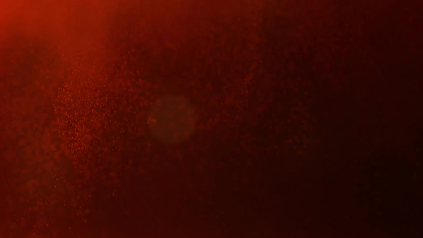A red powder is dropped into a dark liquid