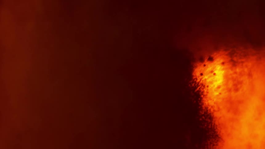 Light filters through the red ink bubbles floating on water