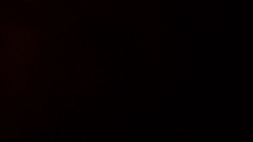 Flashing red light reflecting on a wall in a pitch dark room