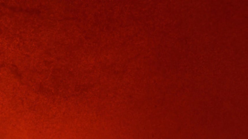 Orange and red particles moving through a liquid