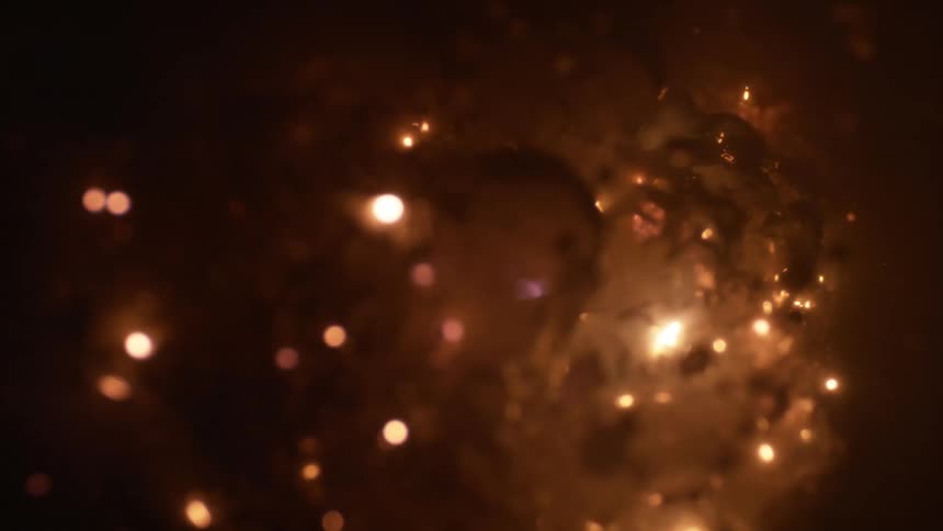 White sparks and smoke bubbling and flickering under liquid
