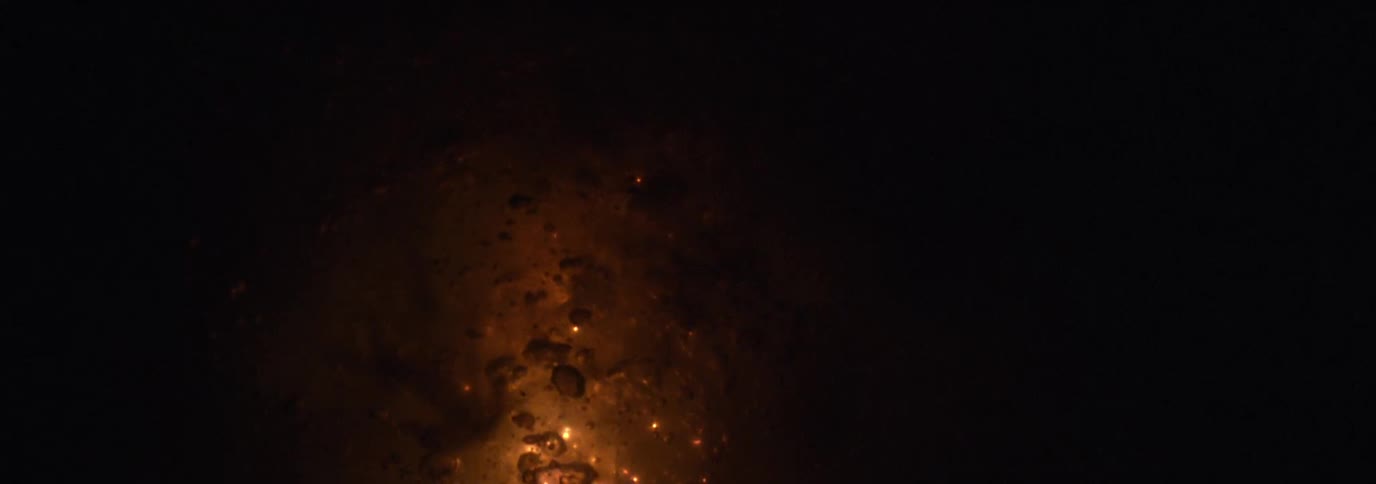 Smoke rises from the burning flames at night