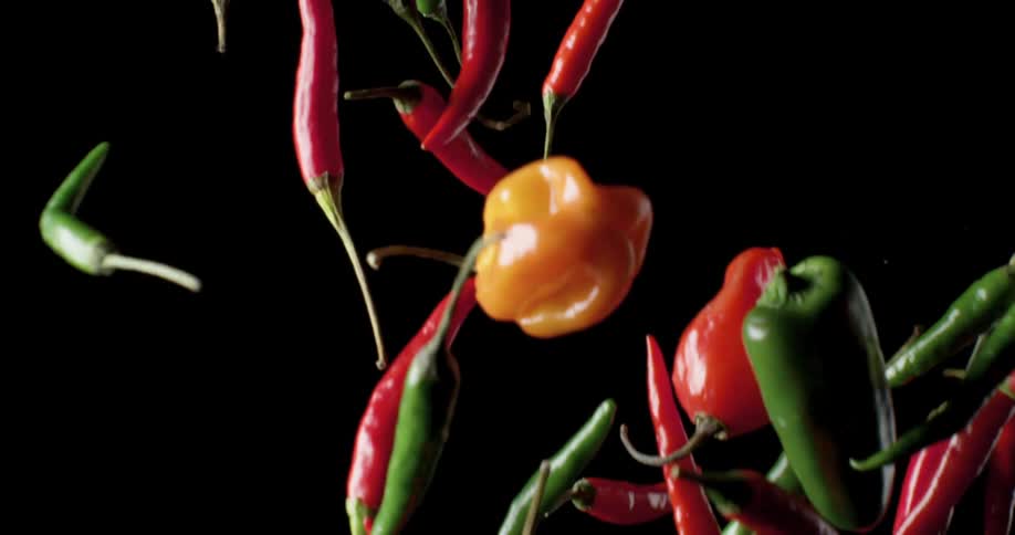Red and green peppers flying through the air
