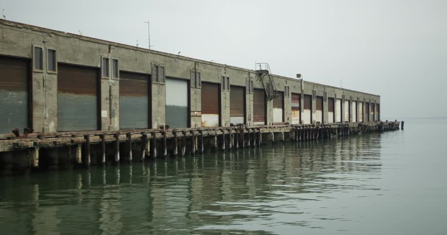 An old warehouse building on an ocean pier on a foggy day