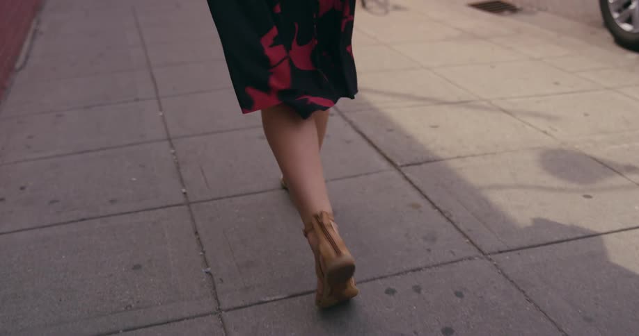 A woman is walking outdoors in a city
