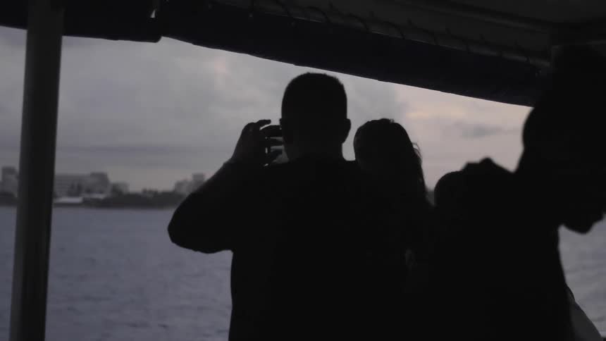 Couple looking from the boat at a view taking a photo