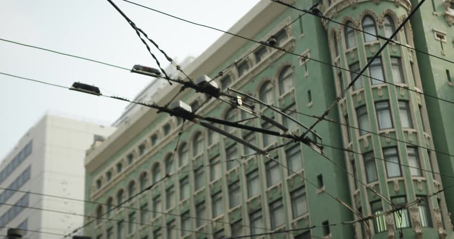 Street wires in front of a tall apartment complex in the city