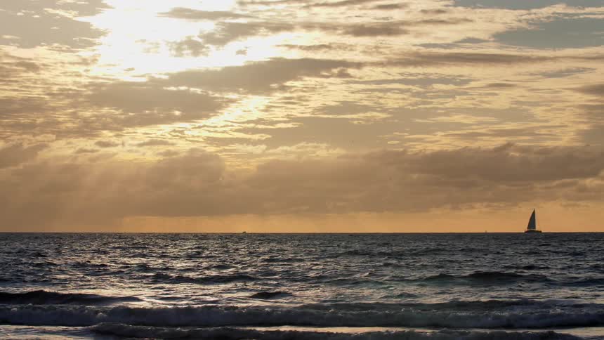Ocean waves lap the shore on a sunny day