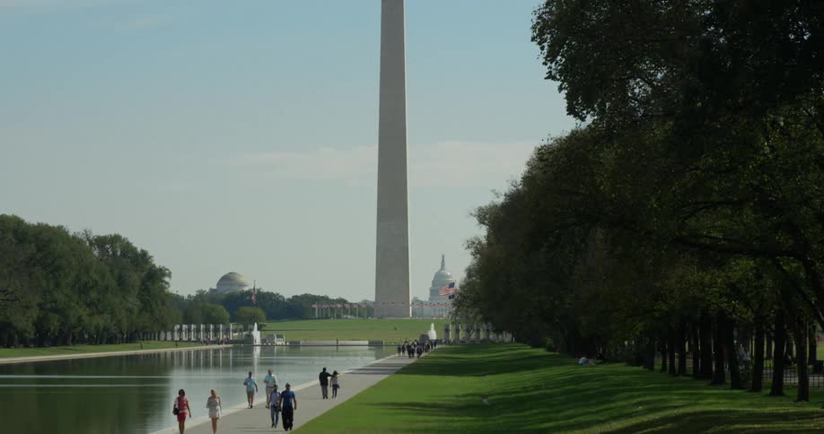 At washington monument showing crowded people walking around water