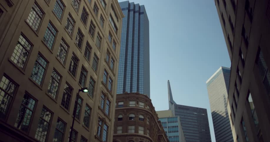 The windows of skyscrapers in a metropolis reflect the clear blue sky