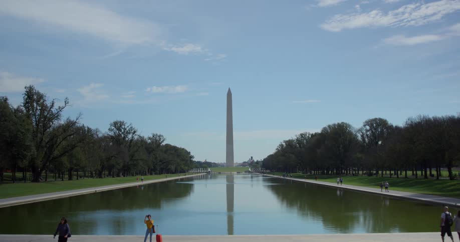 Multiple people walk around a water feature at a national monument