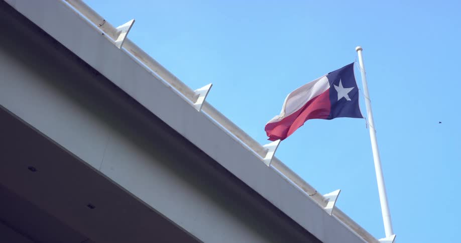 A texas flags waves in the sky
