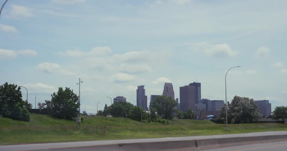 View of a small city skyline from a freeway during summer on a sunny day