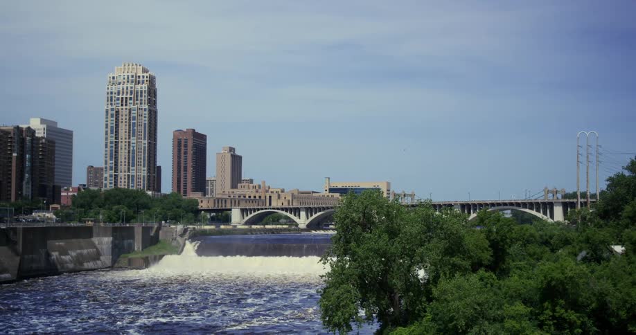 Wide clear water river flowing under the bridge on a big city