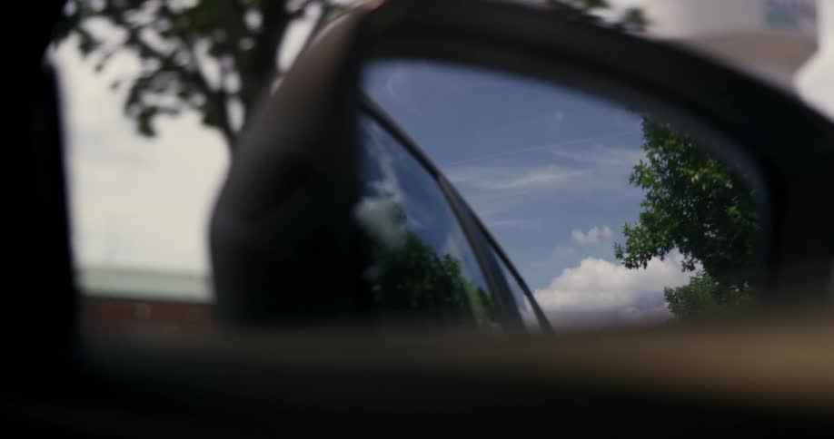A car is driving on a road in spring