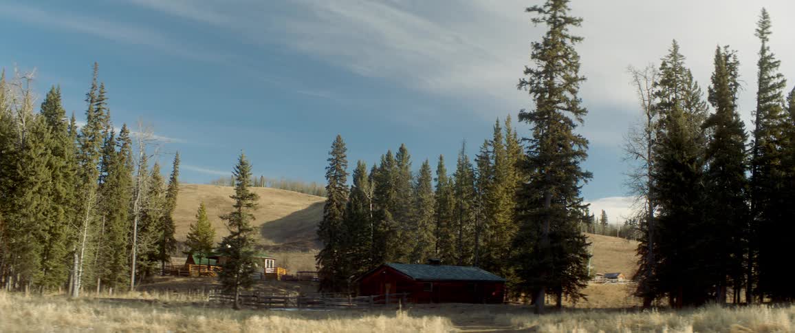 Countryside home surrounded by trees in front of a hill