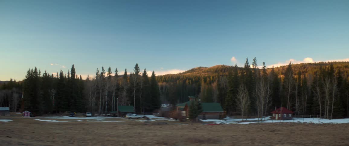 Cabins with trees hills the sky and clouds in the background