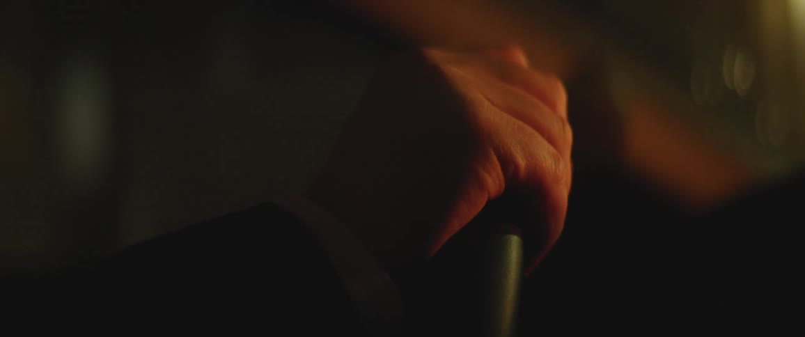 Person driving at night with one hand on the steering wheel