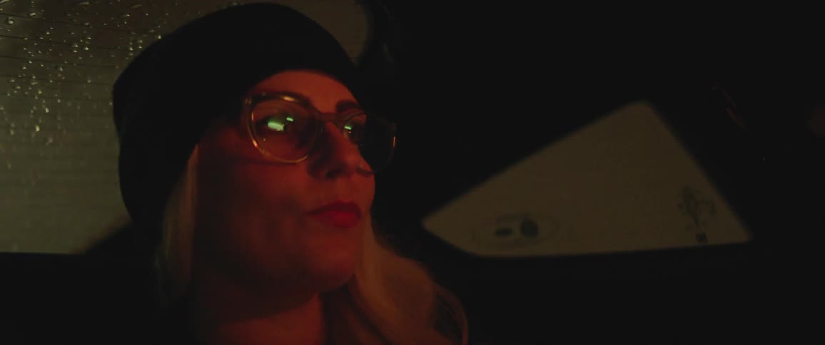 A woman is a passenger in a car at night