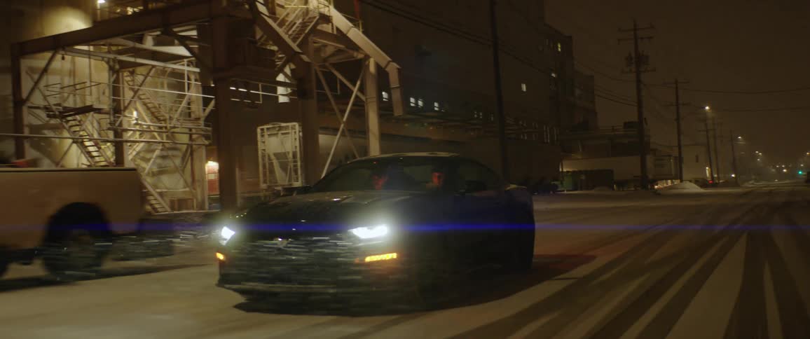 A car is driving on a road at night