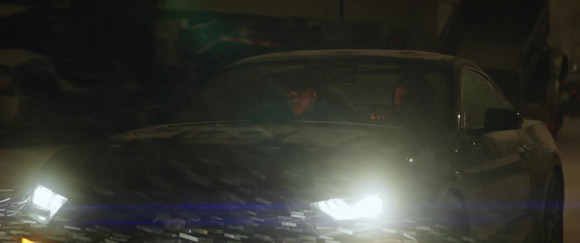 Two people in a car driving in the snow