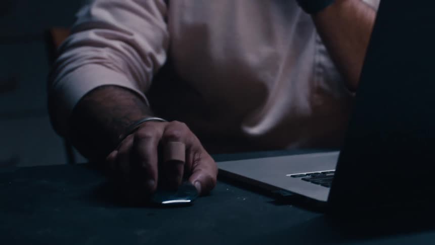 A man is typing on a laptop indoors