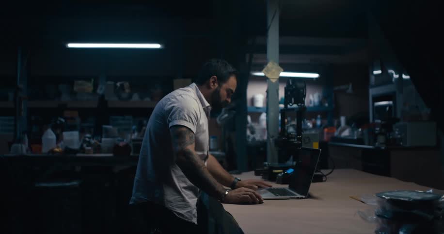 A man in a shop looks at a computer