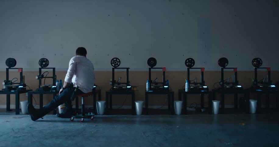 Employee scoots by on spin stool checking machines at work