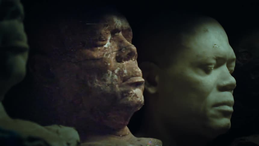 Three busts of man sits side by side in dark as the center most shows damage and a static digital overlay