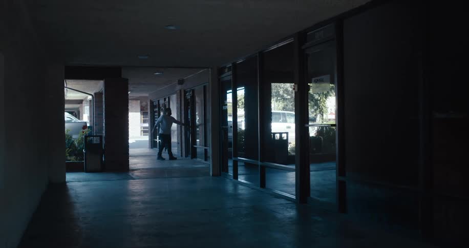 A man opens a door and walks in to a building