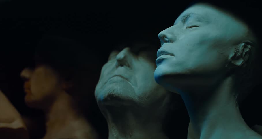 Clay busts of an older male face and a younger female face with eyes closed and in shadows
