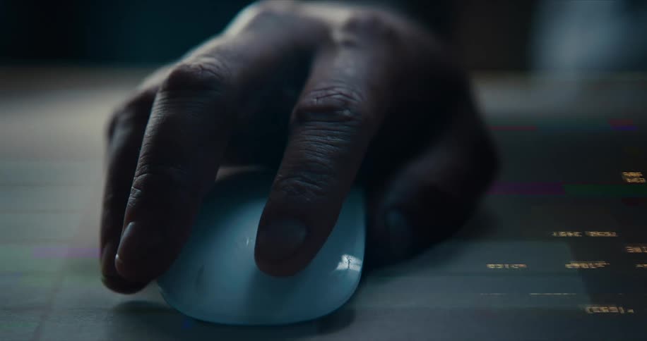 A man uses a mouse with lights and code glitching around him