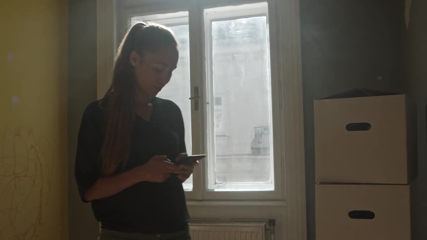 A woman is looking at her cellphone indoors