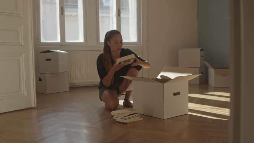 A woman is packing boxes during the day