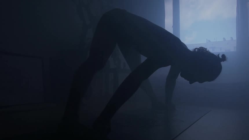 A woman is stretching in a room